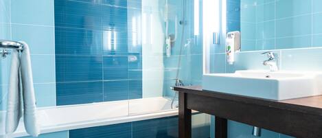 Un baño moderno con una bañera grande, un lavabo y un espejo.