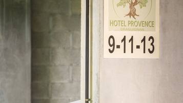 A white car parked in a garage with a sign indicating Hotel Provence Draguignan and dates 9-11-13.