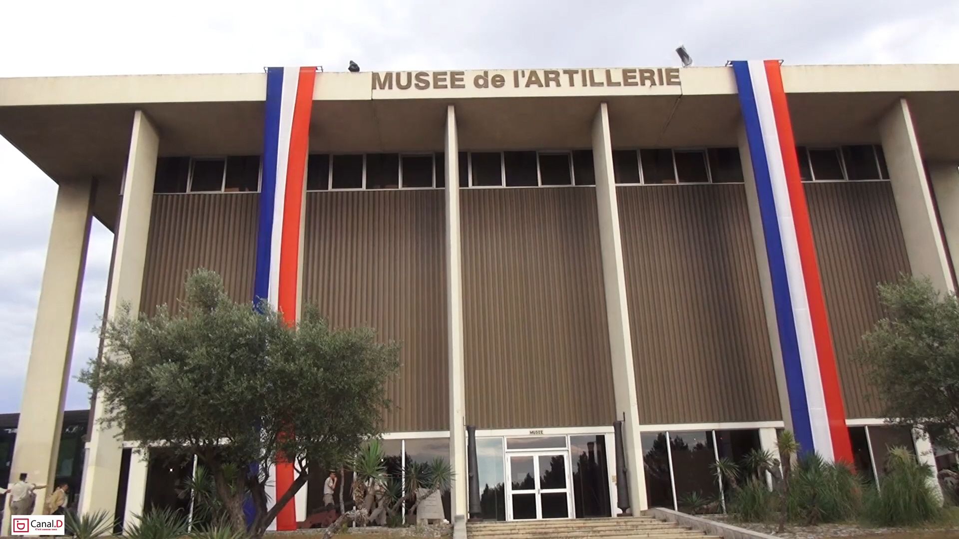 A building with a sign reading "MUSEE de l'ARTILLERIE" and vertical stripes in blue, white, and red.