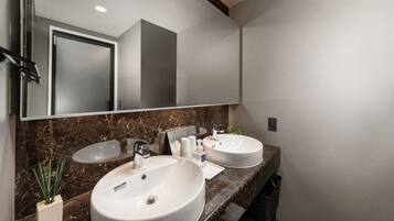 A modern bathroom with two sinks, a large mirror, and a marble countertop.