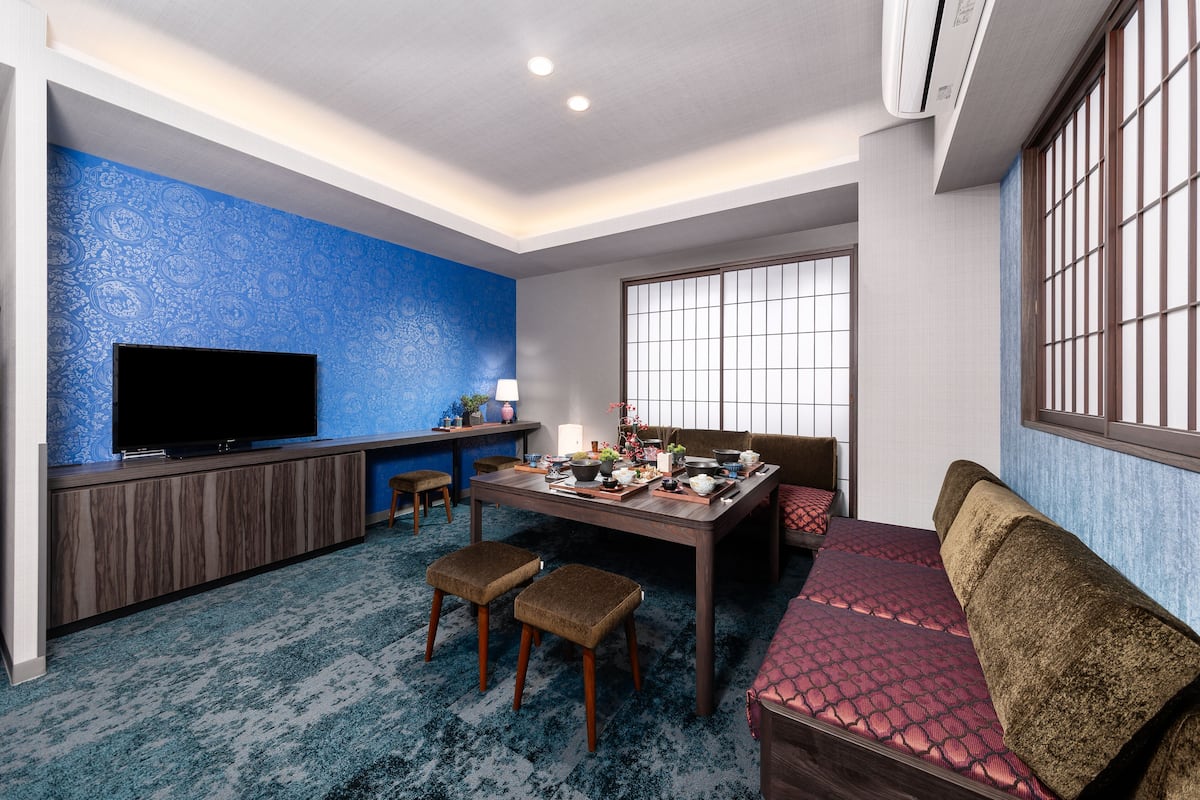 A room with a TV, a dining table, and a sofa.
