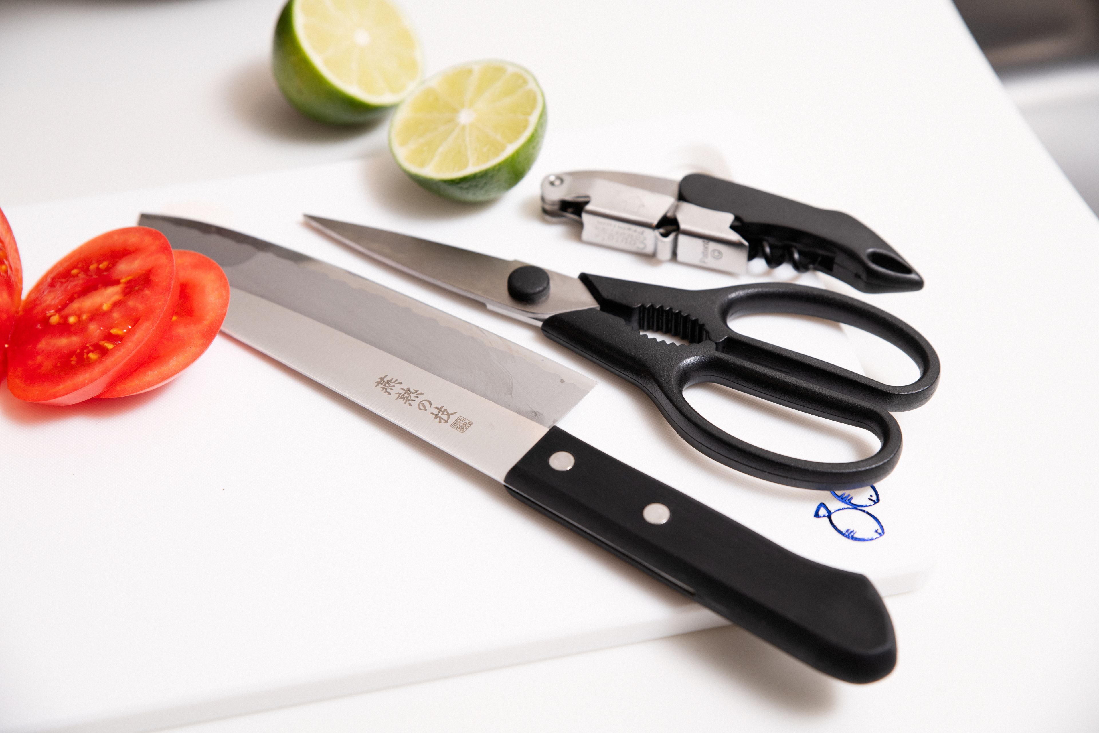 Una encimera de cocina con un cuchillo, unas tijeras y un limón.
