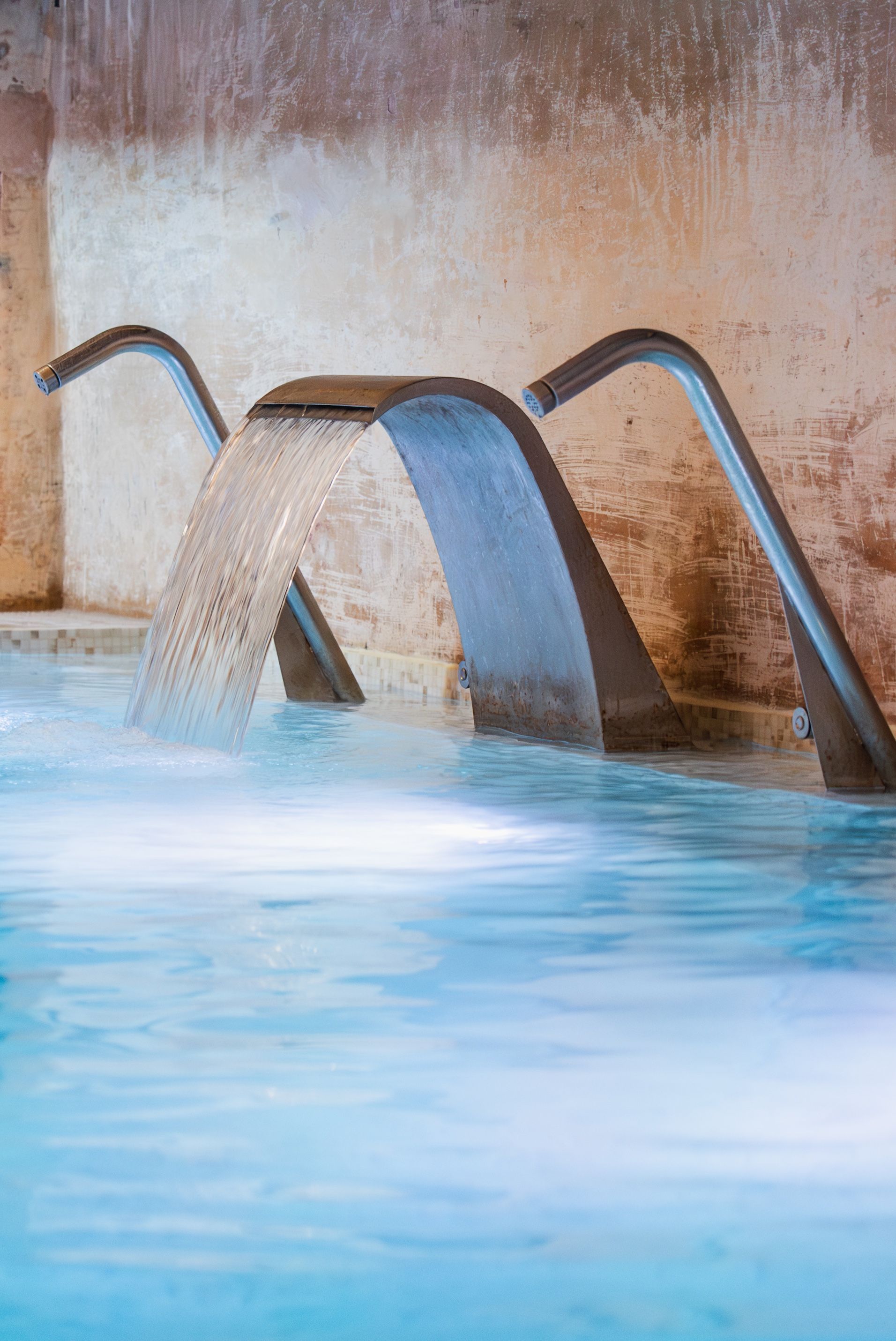 Una fuente de agua con una estructura metálica en una piscina.