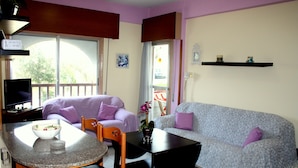 A compact living space with a kitchenette, a sofa, a dining table, and a TV. - Happy Home 4 (Limassol)