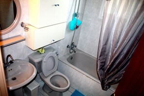 A bathroom with a sink, toilet, and bathtub. - Happy Home 4 (Limassol)