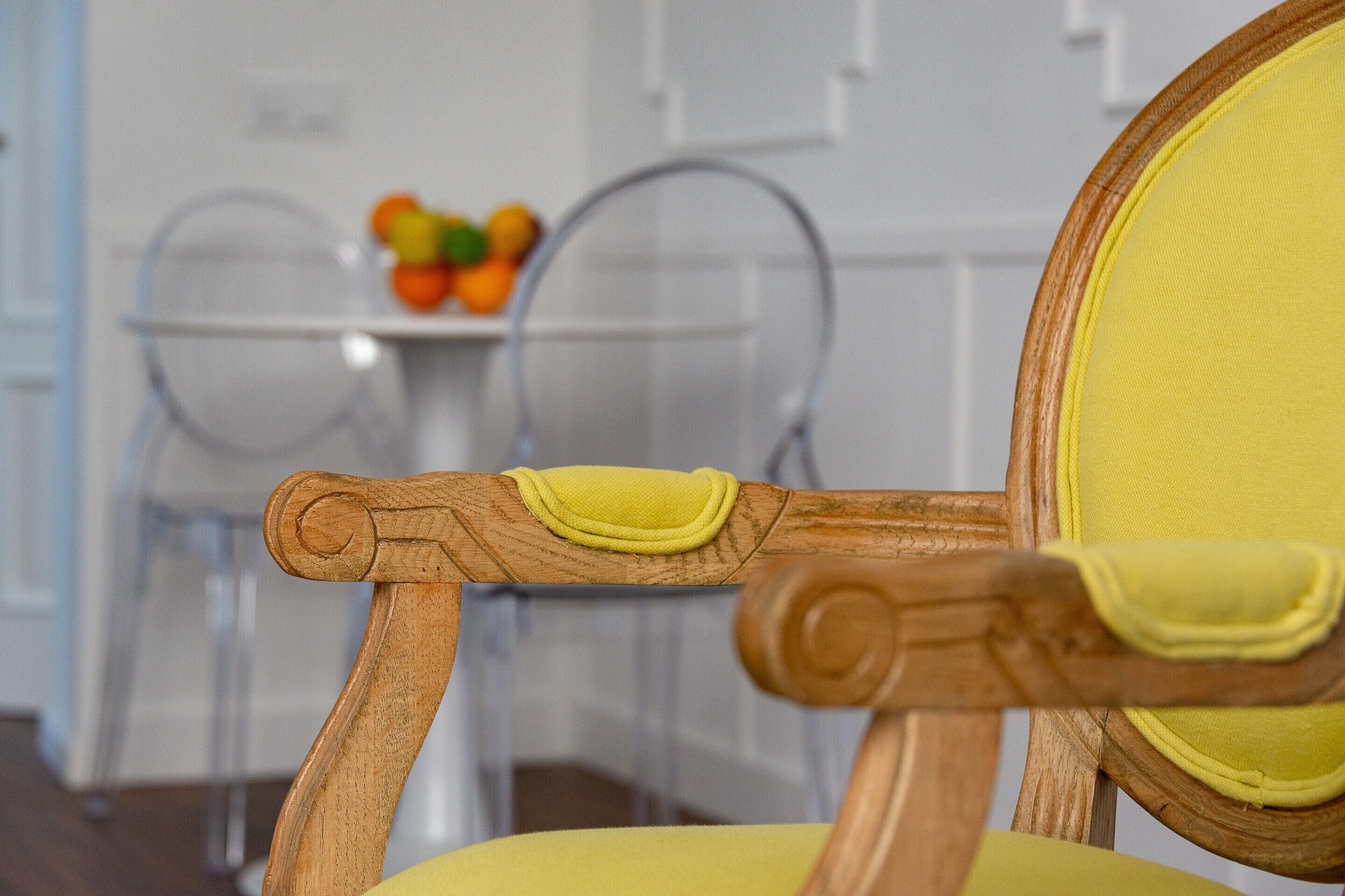 A wooden chair with a yellow cushion and a round backrest.
