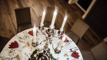 Una mesa vestida con un mantel blanco, un centro de mesa floral y un candelabro con velas encendidas.
