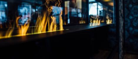 Un bar con una superficie reflectante, posiblemente un espejo, y una persona en el reflejo.