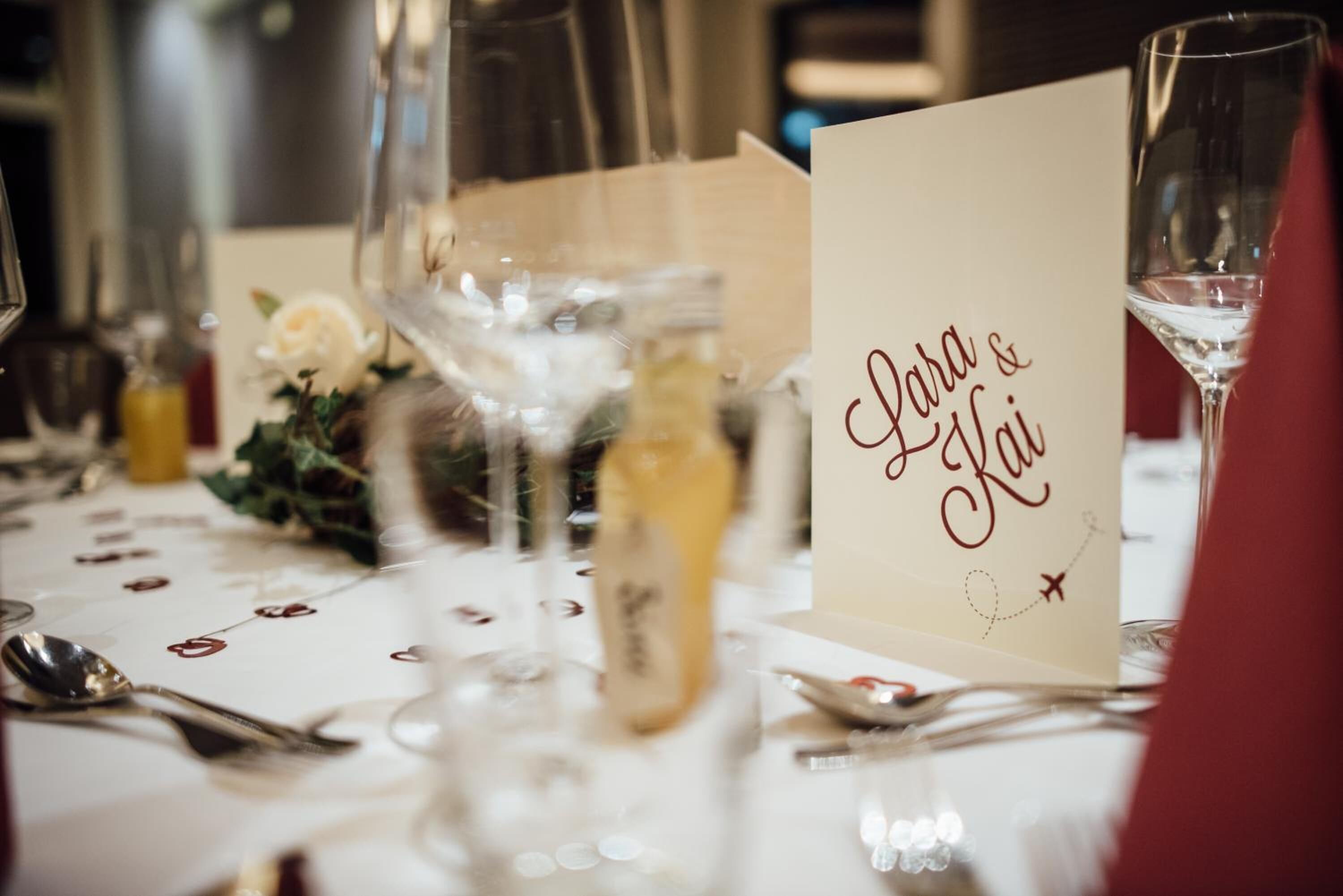 A table set with wine glasses, a bottle, and a menu card.