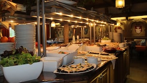 A buffet setup with various food items and serving utensils.
