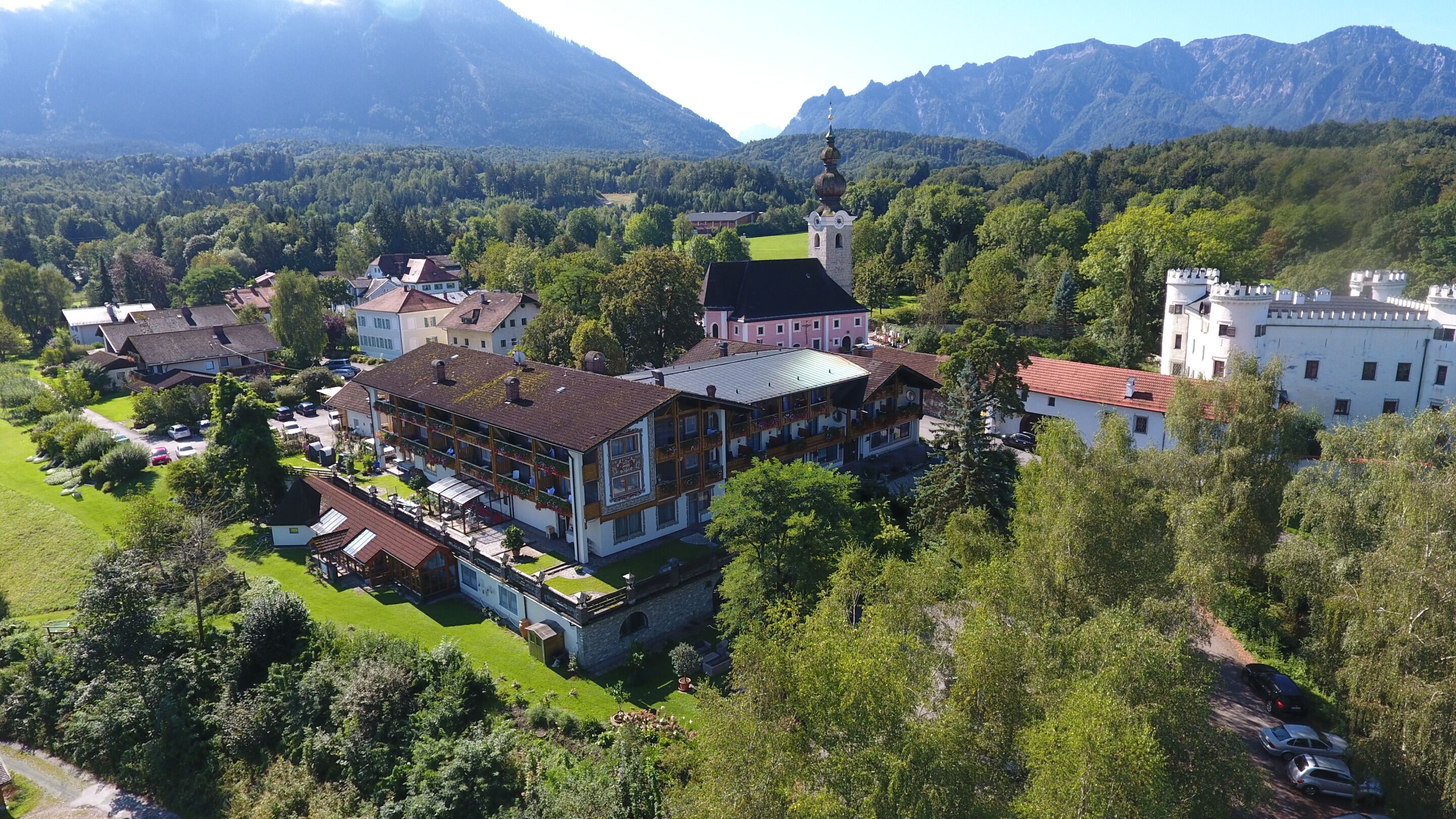 Ein traditionelles europäisches Dorf mit einer markanten Kirche, einer Burg und verschiedenen Wohnhäusern.