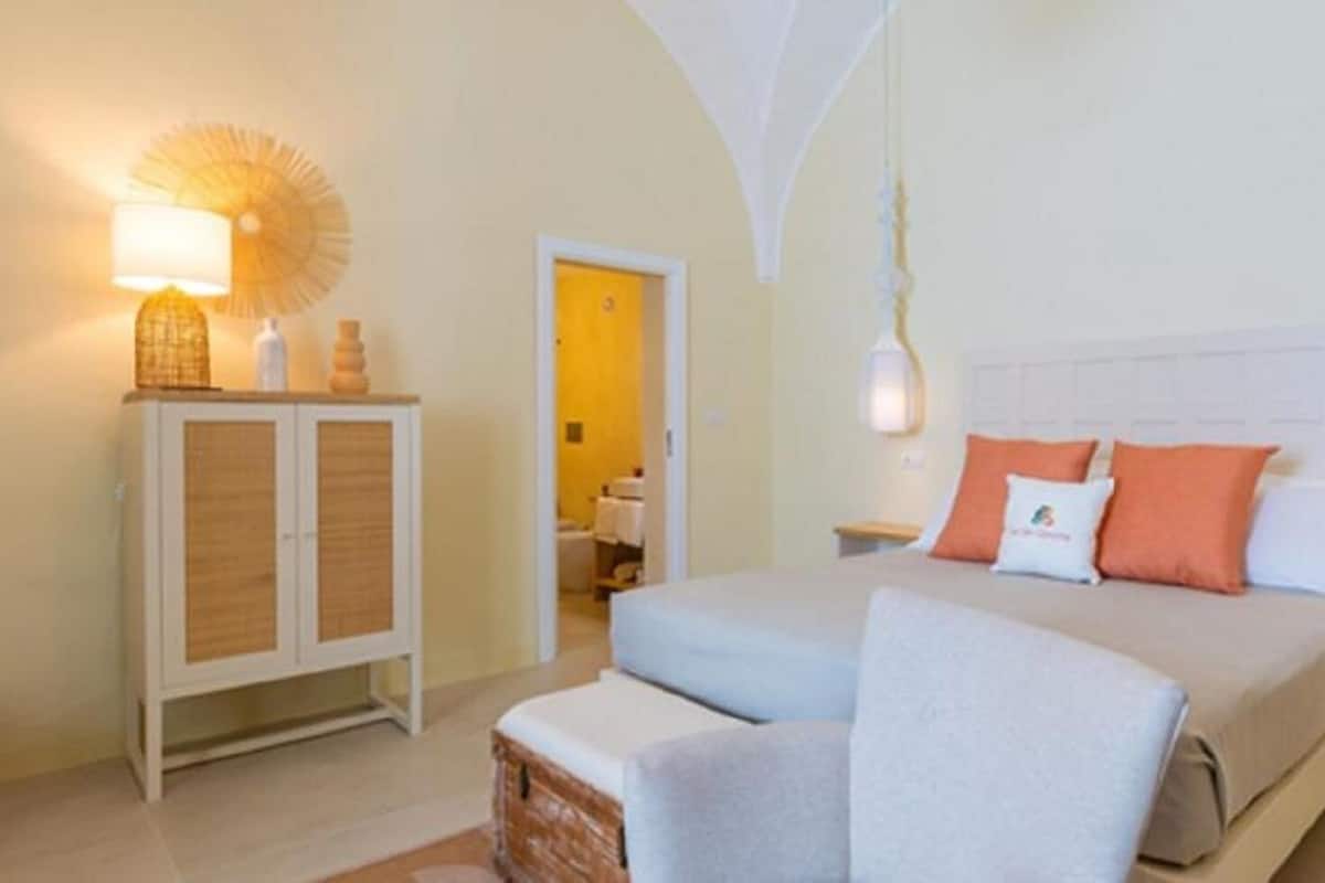 A bedroom with a bed, a nightstand, a cabinet, and a chair.