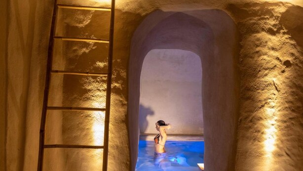 A stone archway leading to a hot spring with a ladder on the left. - Le Sei Conche Relais & Spa (Ugento)