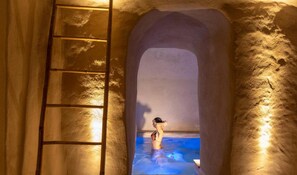 A stone archway leading to a hot spring with a ladder on the left. - Le Sei Conche Relais & Spa (Ugento)