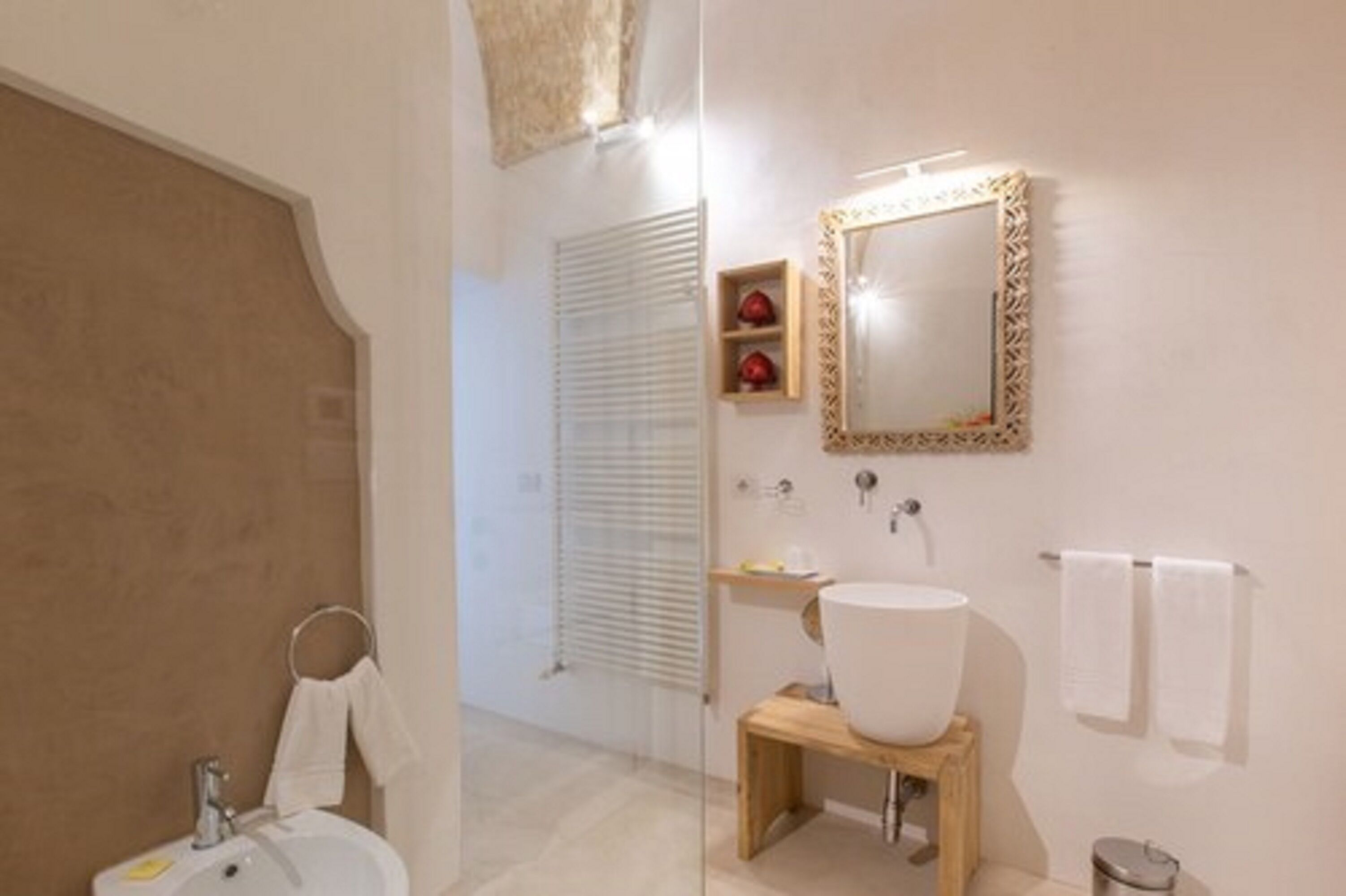 A bathroom with a large mirror, a sink, and a towel rack.