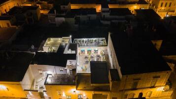 Vista aerea di un hotel con diversi piani, stanze collegate e un cortile centrale con posti a sedere all'aperto.