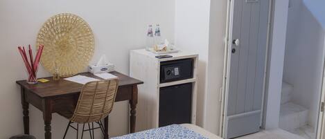 Une chambre comprenant un lit, un bureau avec une chaise, un four à micro-ondes et un petit réfrigérateur.