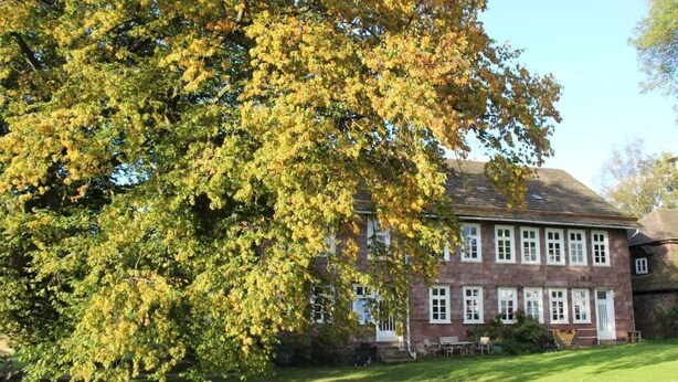 A large brick building with multiple windows and a well-maintained lawn. - Gutshof Fürstenberg (Fürstenberg)