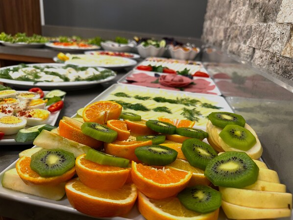 A buffet with various dishes including fruit and salads.