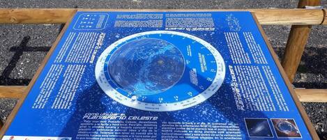 Un planisfério celestial con un mapa estelar central y texto explicativo.