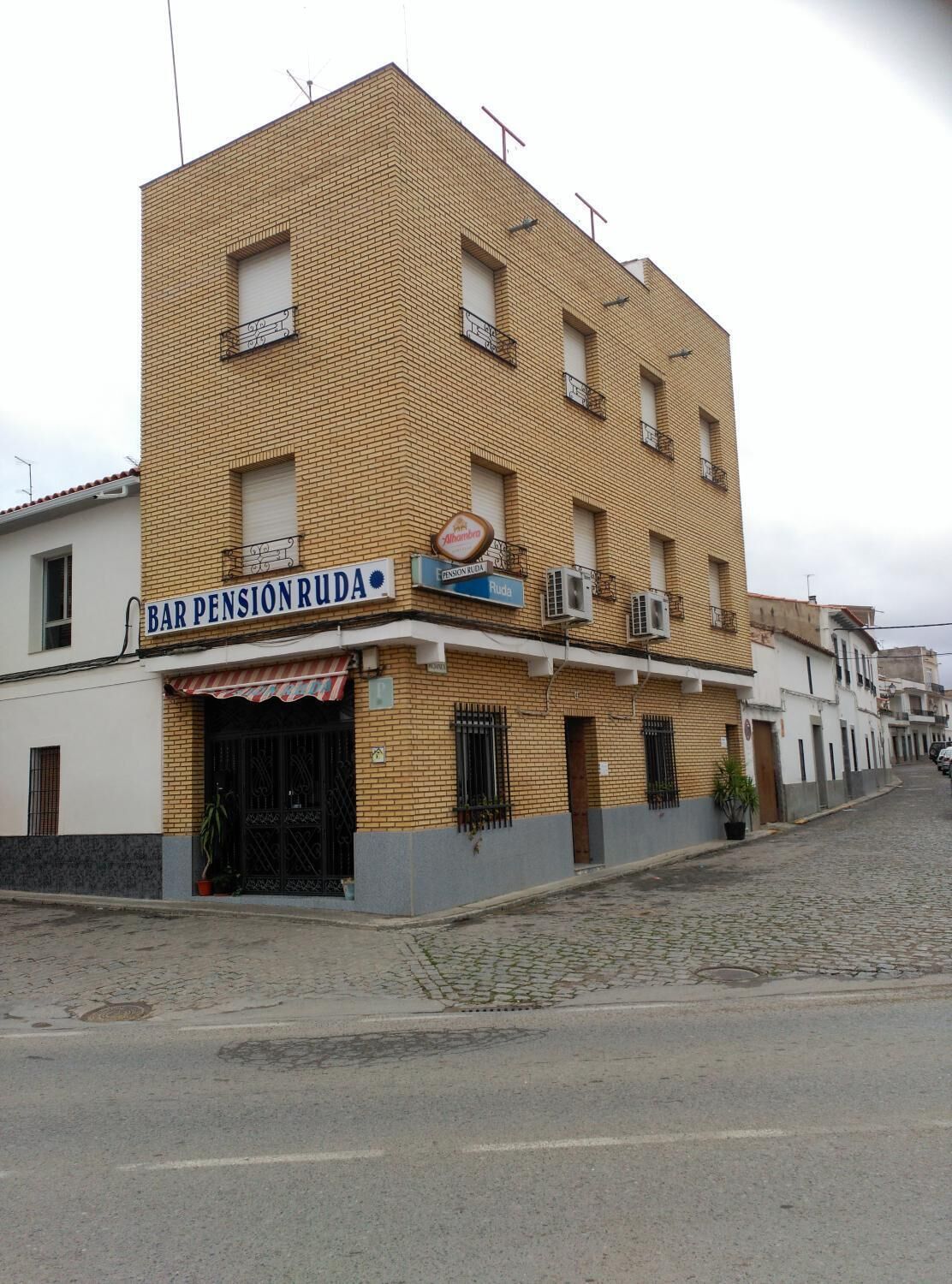 A multi-story building with a sign for 'BAR PENSION RUDA'.