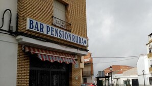 A building with a sign reading "BAR PENSION RUDA" and a red and white awning. - Pension Ruda (Hinojosa del Duque)