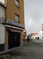 Un edificio con un letrero que dice "BAR PENSION RUDA" y un toldo rojo y blanco.