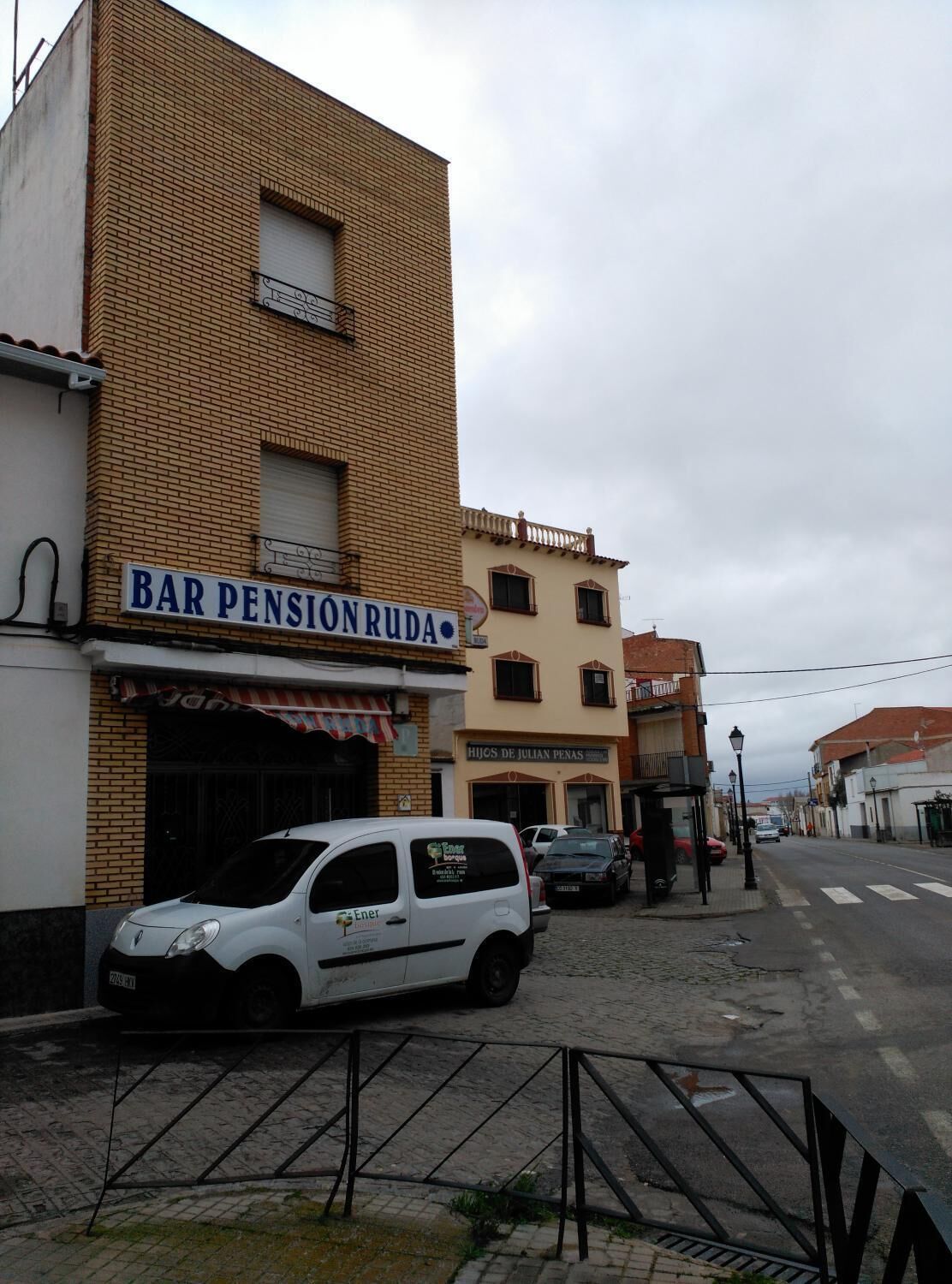 A building with a sign reading "BAR PENSIONRUDA" and another sign for "HIJOS DE JULIAN PENAS".