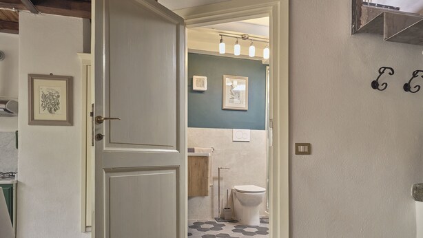 Un baño con inodoro, lavamanos y zona de ducha.