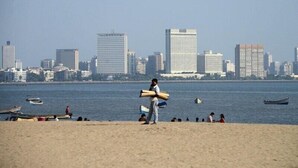 Una playa con el perfil urbano del fondo.