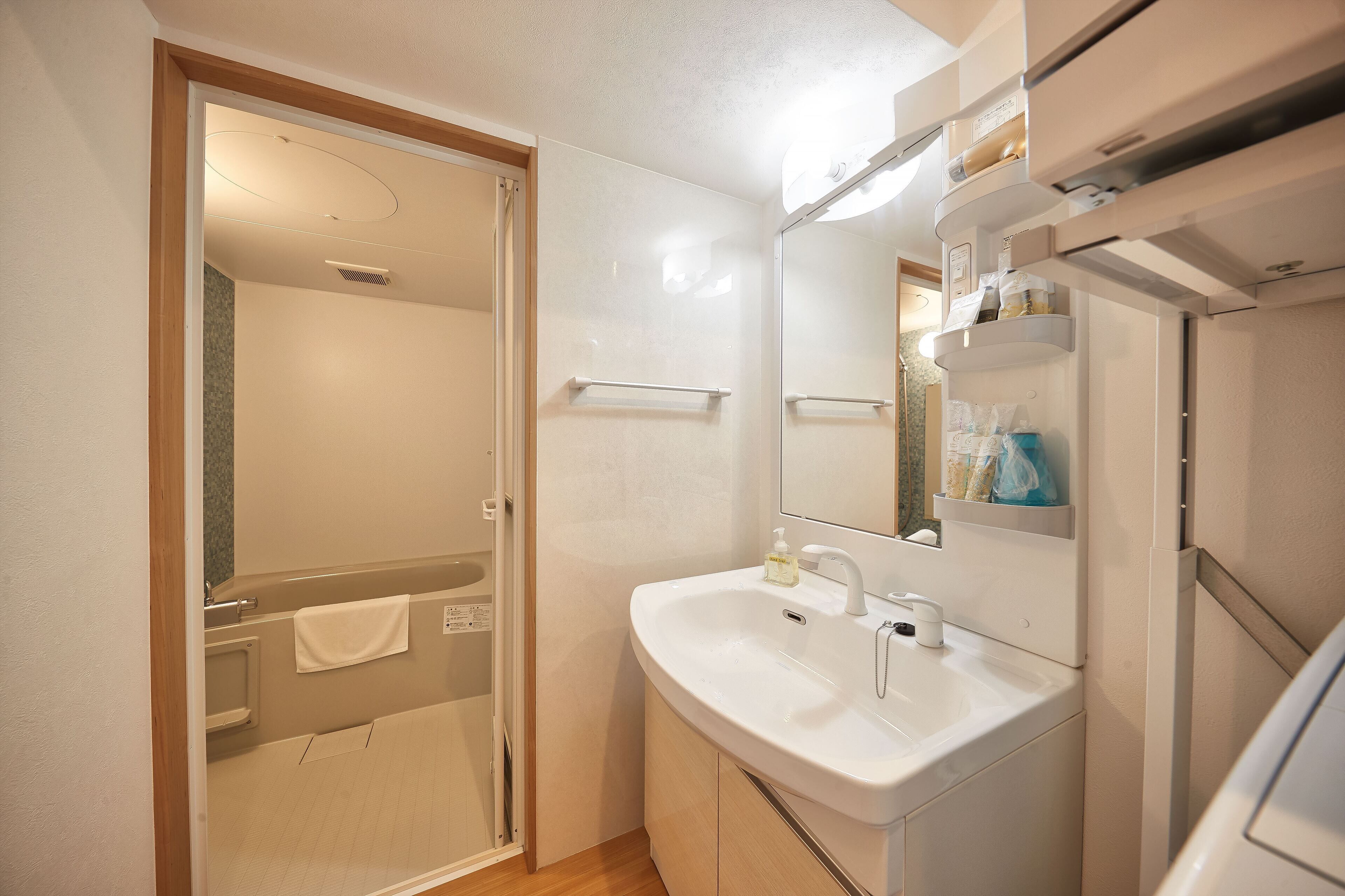Un baño con ducha, lavabo y espejo.