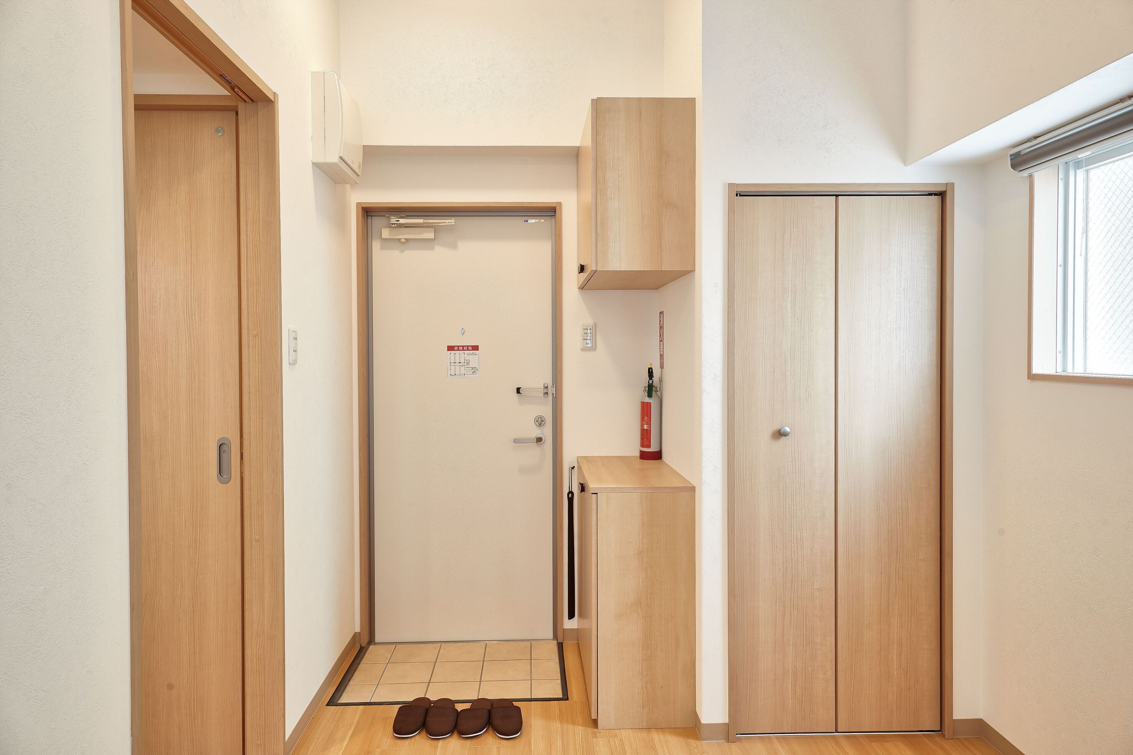 A hallway with wooden doors, a small cabinet, and a fire extinguisher.