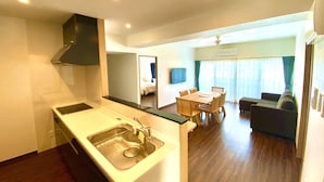 Una cocina moderna con un lavaplatos integrado y una zona de comedor con una mesa y sillas de madera.