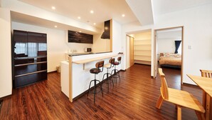 Una cocina moderna con una isla central, taburetes de bar y una mesa de comedor.