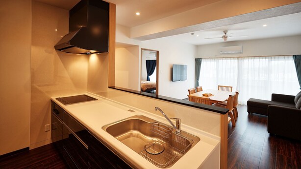 Una cocina moderna con estufa integrada, pileta y campana extractora.