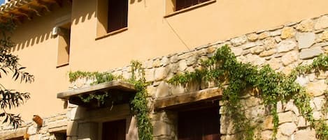 A traditional building with stone walls, wooden doors, and a tiled roof.