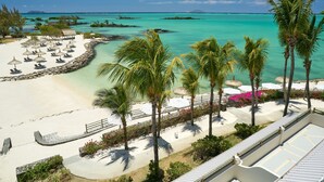A beach resort with sun loungers, palm trees, and a clear turquoise sea. - Lagoon Attitude - Adults Only (Calodyne)