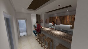 Une cuisine moderne avec un plan de travail en bois, des tabourets de bar et des luminaires suspendus.