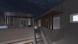 Un intérieur moderne avec un escalier menant à un deuxième étage, un mur en pierre et une fenêtre sur la droite.