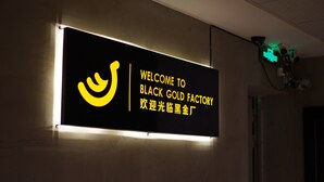 Een bord met de tekst 'WELCOME TO BLACK GOLD FACTORY' en een gestileerd logo.
