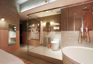A modern bathroom with a glass-enclosed shower, a large bathtub, and a visible toilet.