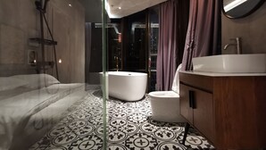 Een moderne badkamer met een groot bad, een aparte douche en een wastafelmeubel met een wastafel.