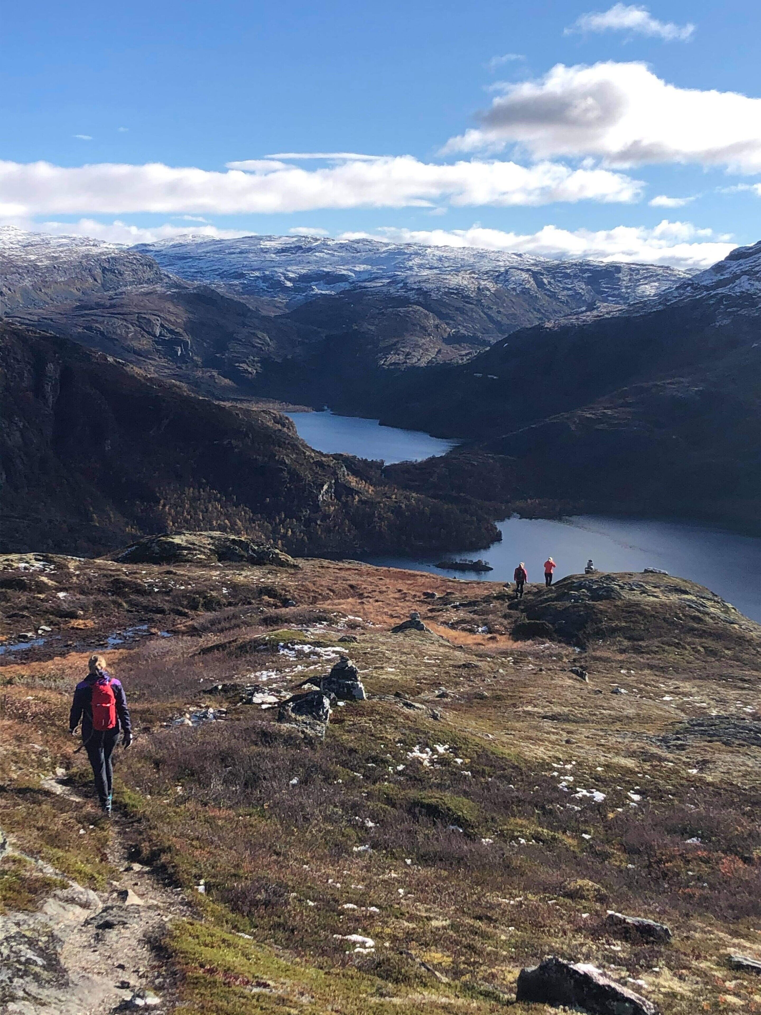 Vuoristoinen maisema, jossa on järvi, kivikkoista maastoa ja kirkas taivas.