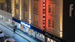 Un hôtel reconnaissable à son grand panneau rouge, à ses nombreuses fenêtres et à sa façade sur laquelle on peut voir une enseigne.