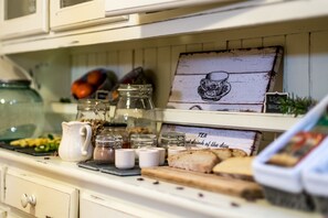 Una encimera de cocina con frascos, una jarra y un cartel que dice 'TEA'.
