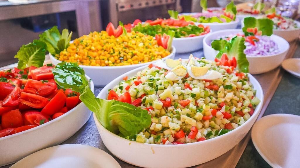 Variedad de ensaladas coloridas en boles, dispuestas sobre una mesa.