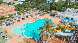 An aerial view of a resort with a swimming pool, sun loungers, umbrellas, and a water slide. - Hotel Royal Jinene (Sousse)