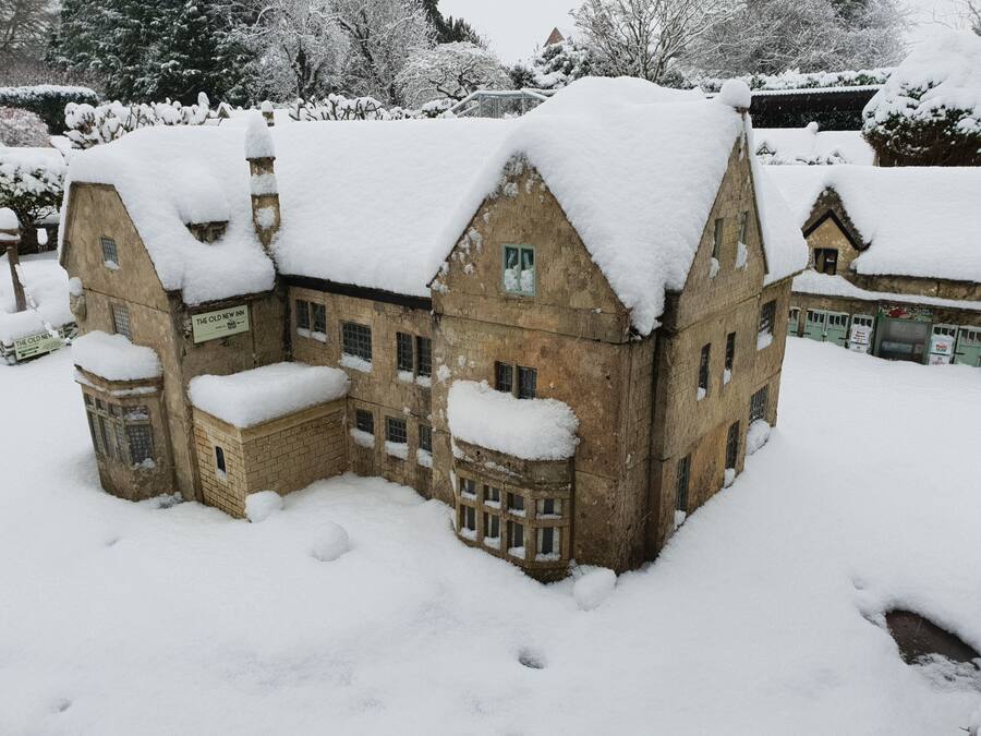 Un edifici històric amb diverses finestres i un teulat cobert de neu, envoltat de neu.