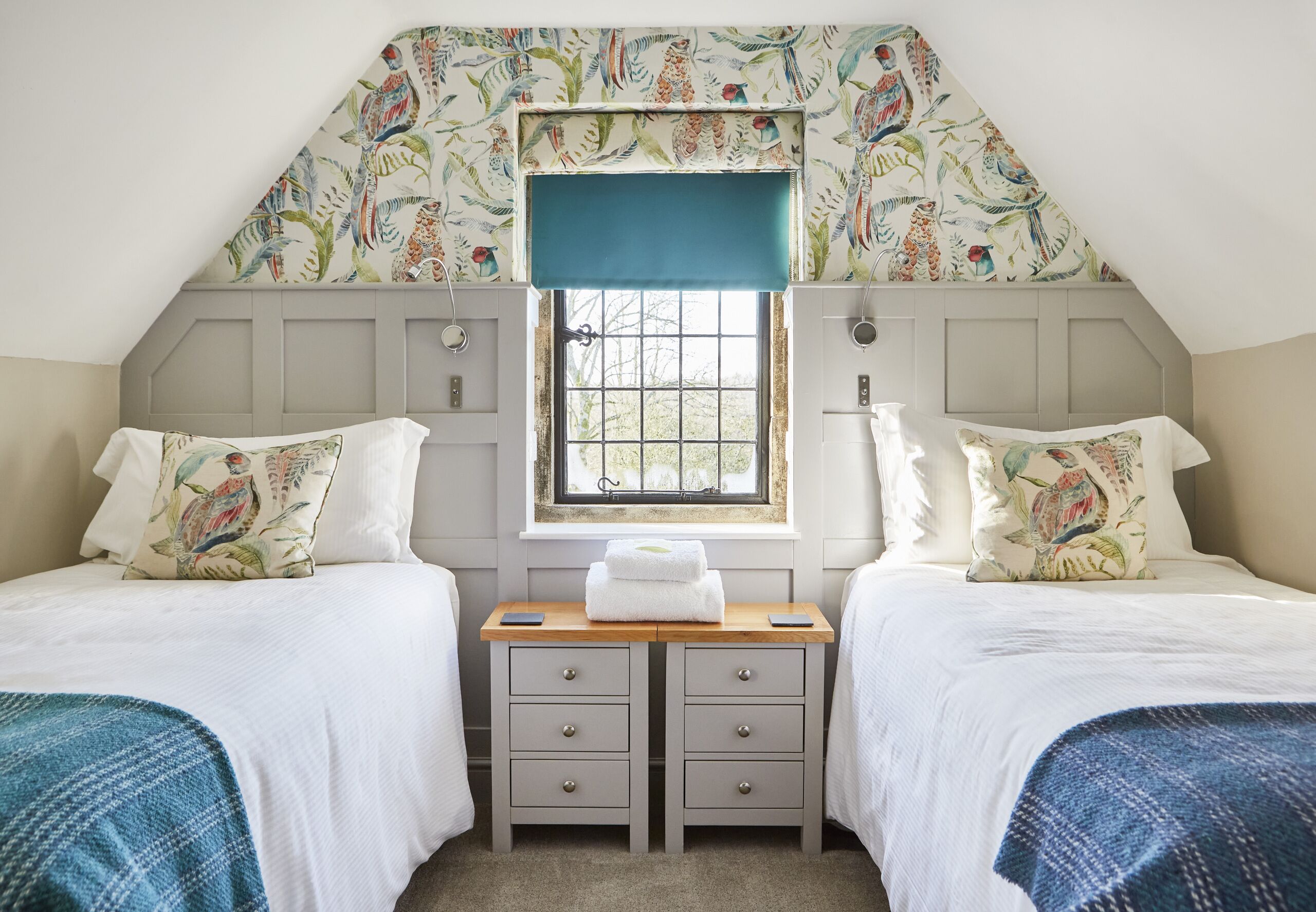Un dormitorio con dos camas, un escritorio pequeño y una ventana con vistas.