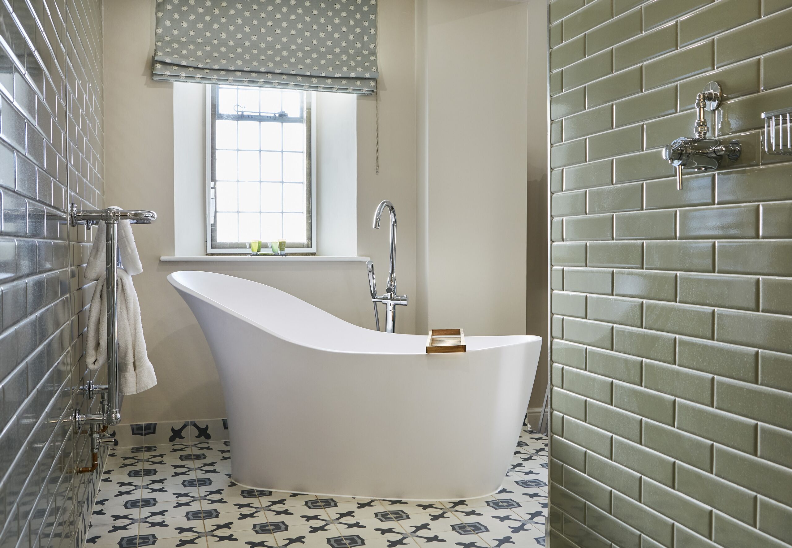 Une salle de bain moderne avec une baignoire sur pieds, une fenêtre offrant une belle vue et un sol carrelé.
